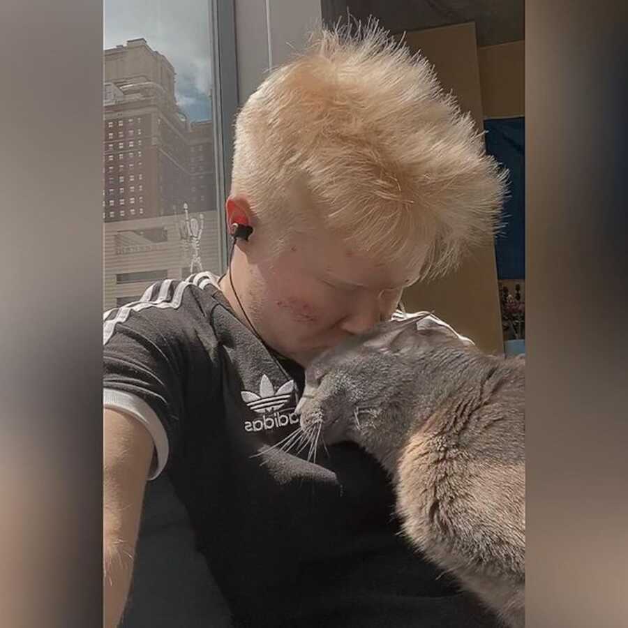 albino man with his cat
