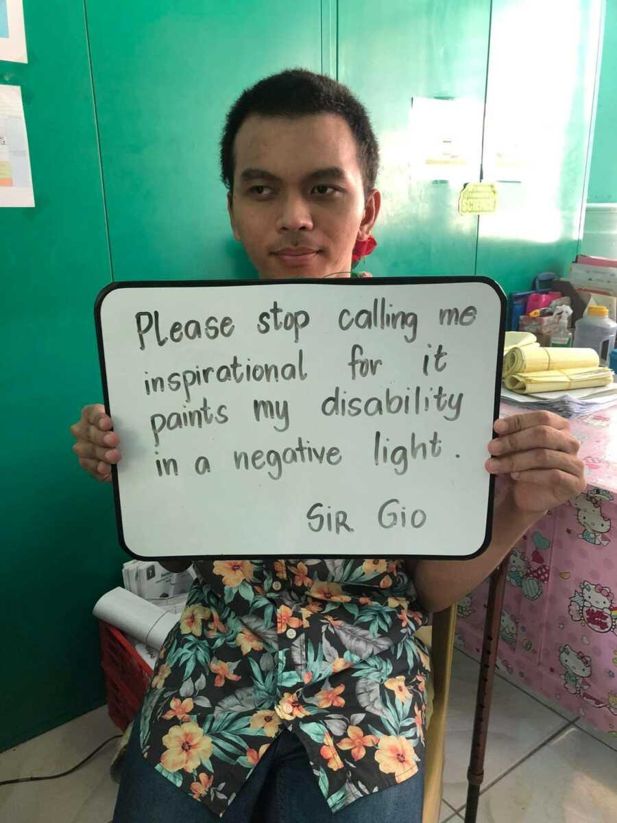 cerebral palsy man holding up a message to people