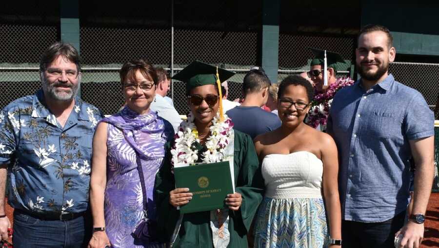 woman with her family in graduation cap and gown