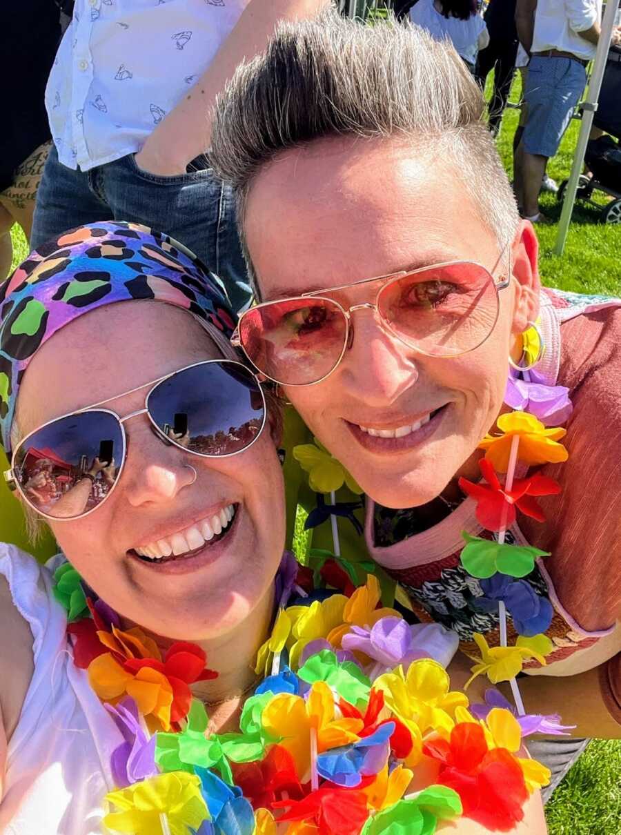Wives at pride in rainbow flower necklaces