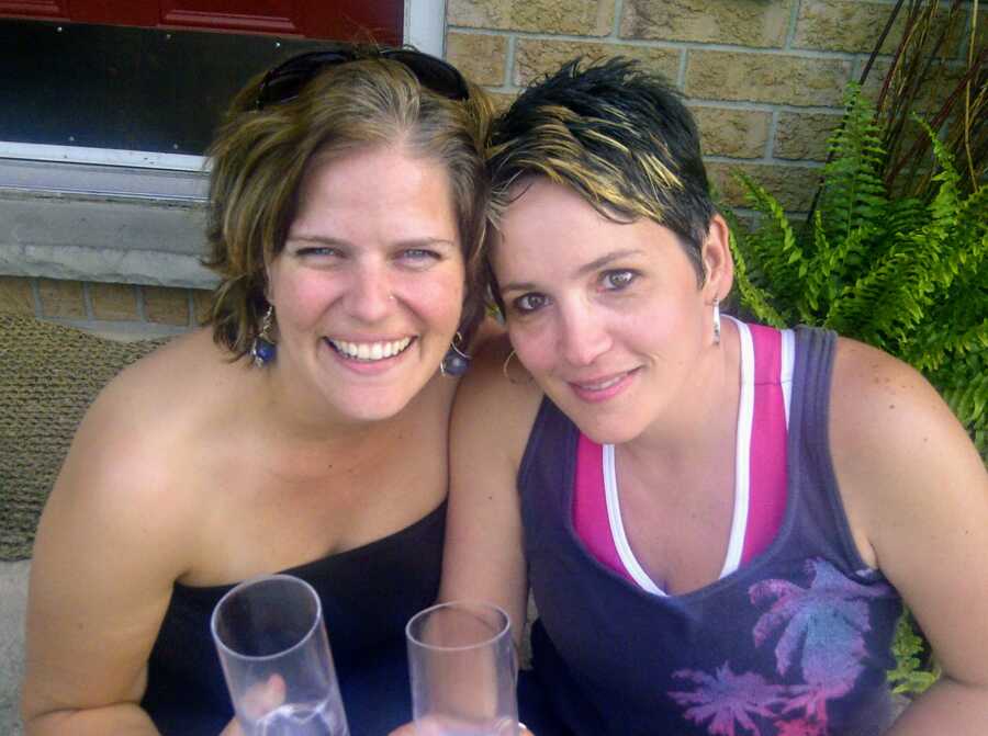 Two mothers smiling together with champagne flutes