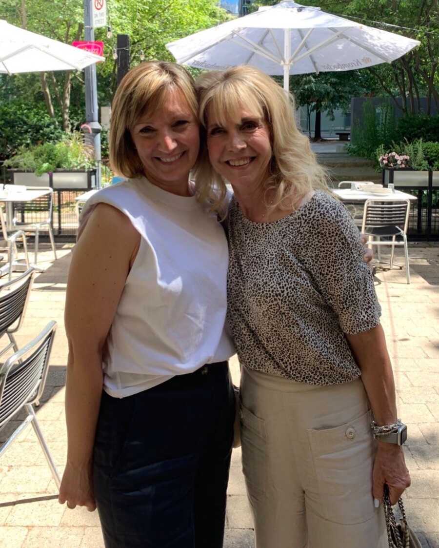 two woman standing together smiling