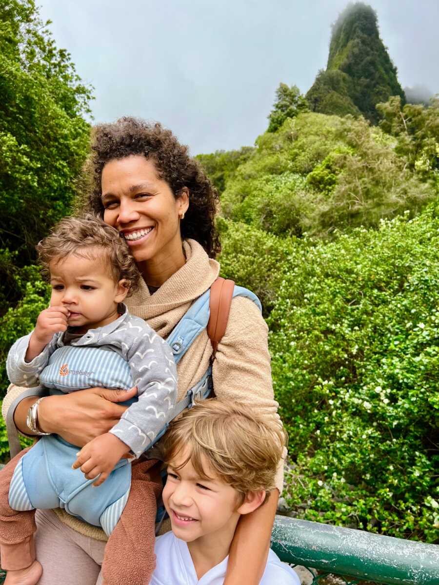 Widow standing in jungle with two sons