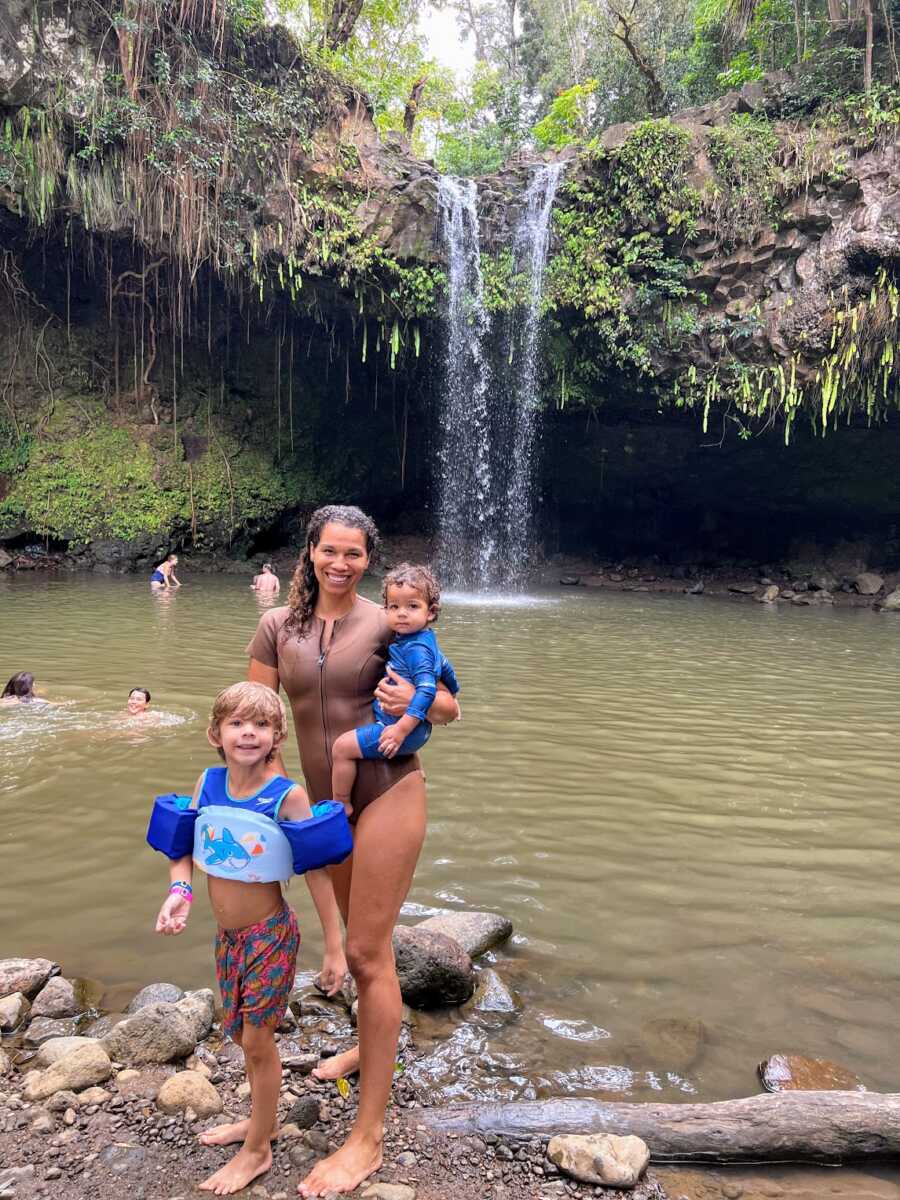 Widow standing by a jungle lake with her two sons