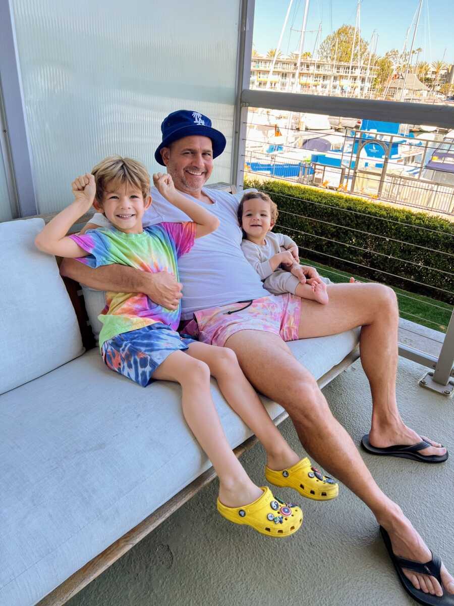 Father sitting with his two sons on a balcony