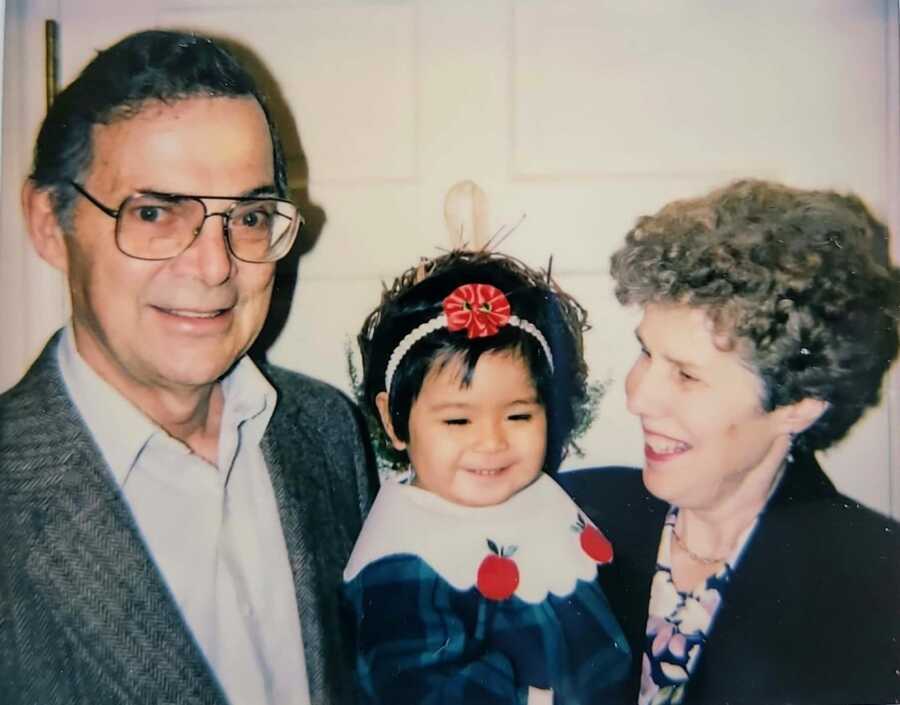 Grandparents holding adopted granddaughter