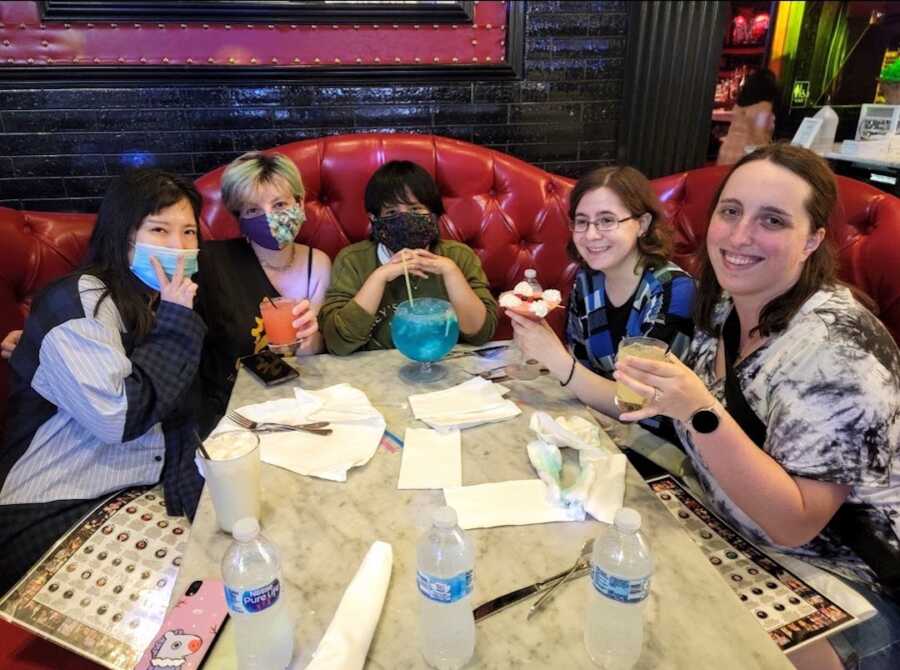 Group of women sitting around a table in a red booth