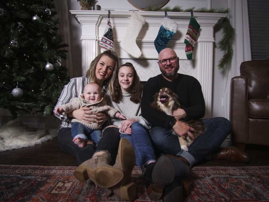 family photo together in front of fireplace with Christmas stockings