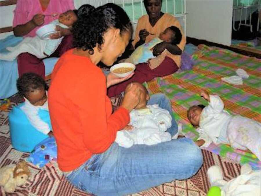 Group of women feeding orphan children at a Ethiopian orphanage