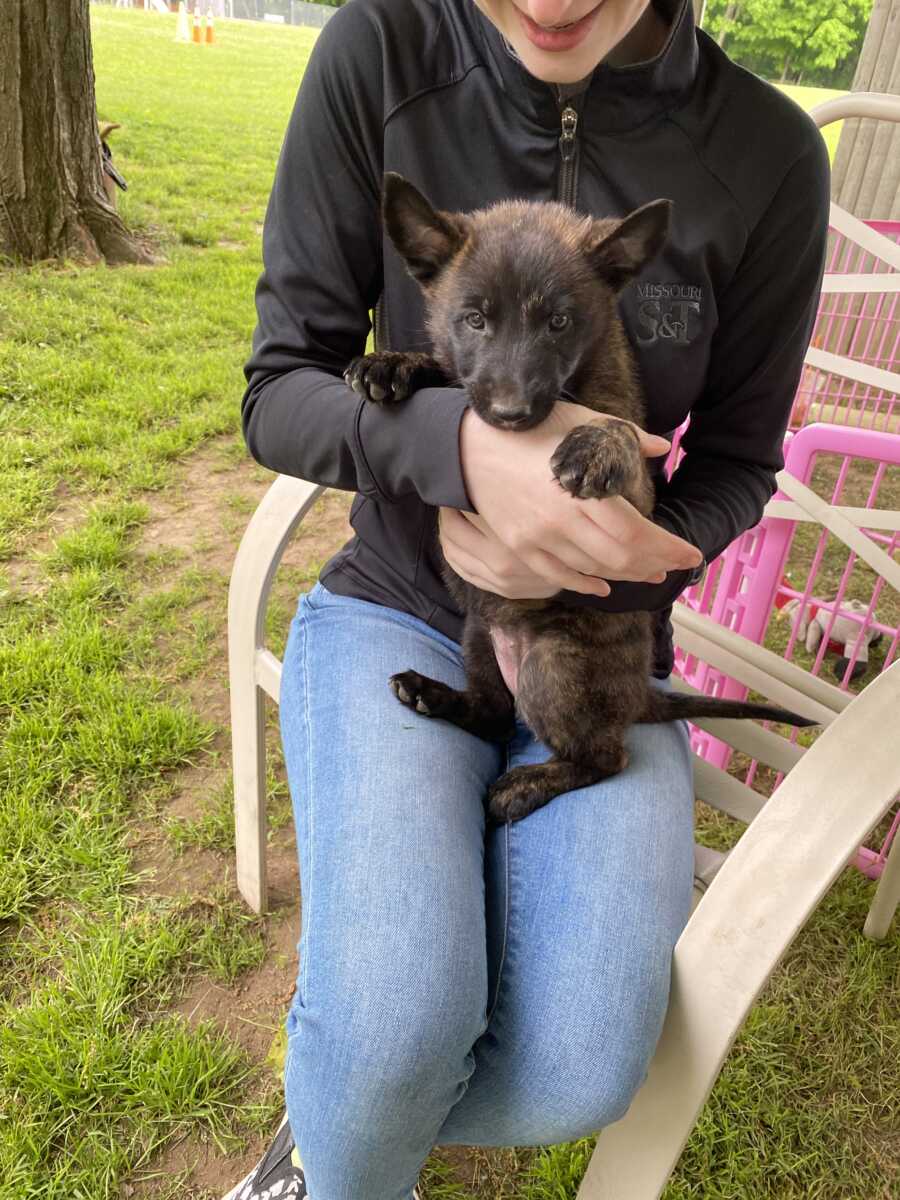 woman holding her service dog as a puppy