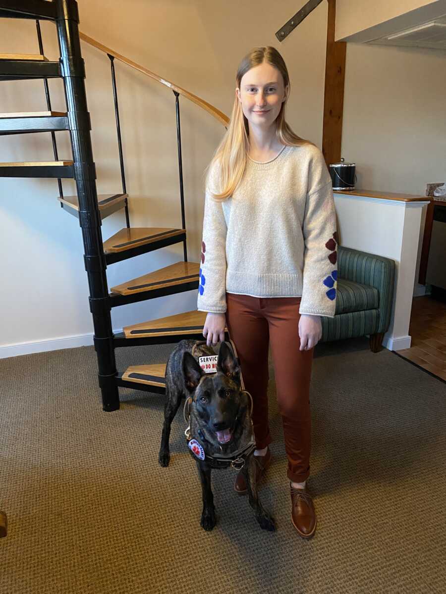 smiling service dog with her owner