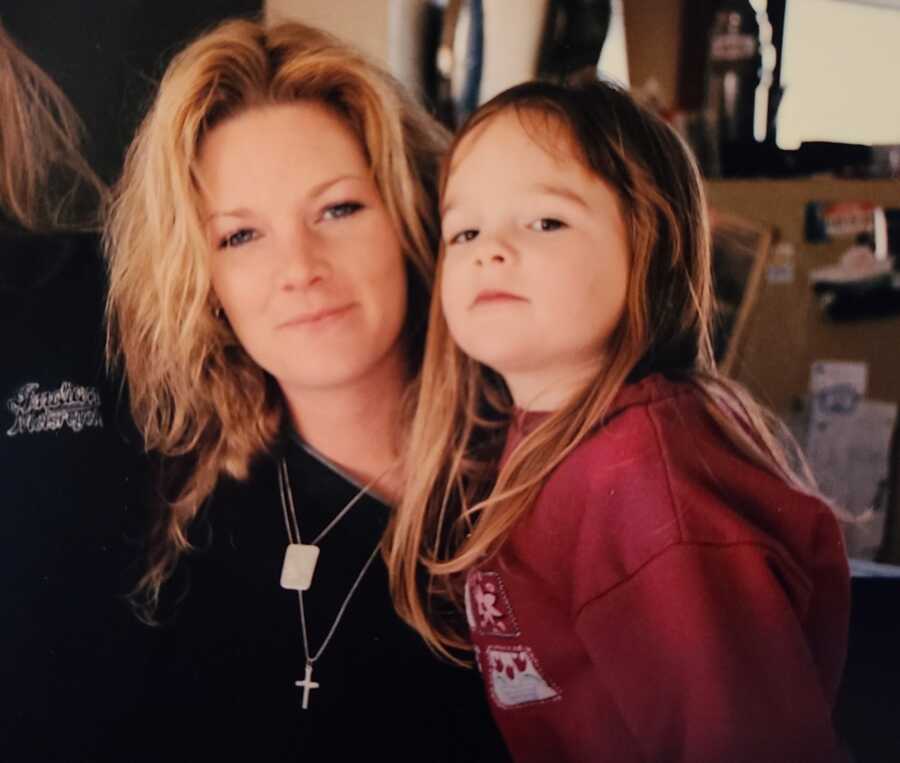 Single mother and young daughter looking into camera