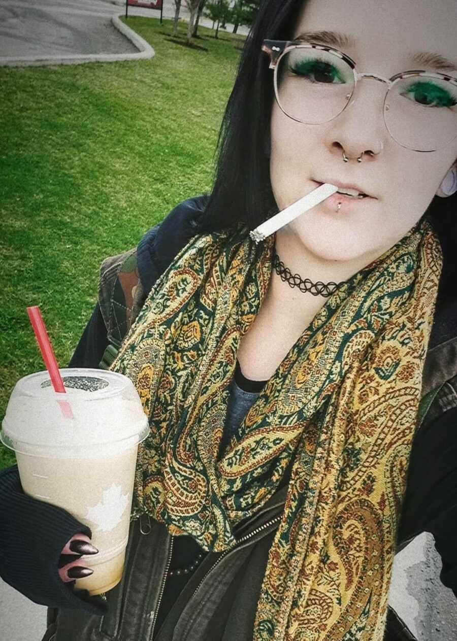 Female drug addict holding a cold drink and smoking