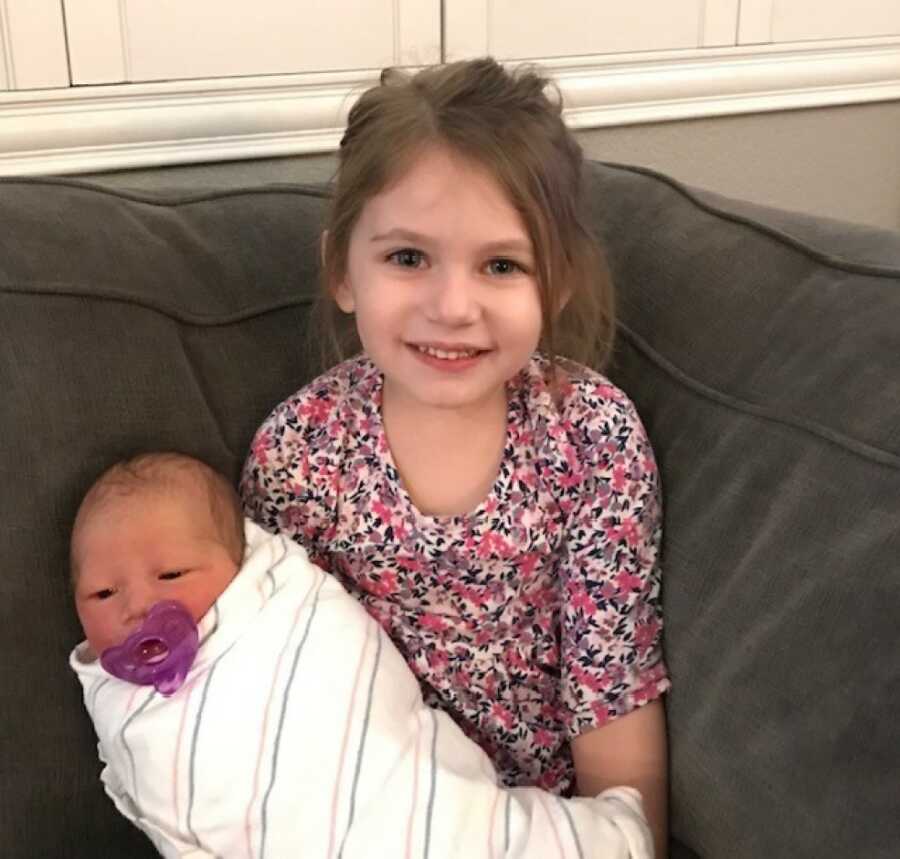sister holding little sister when she was brought home
