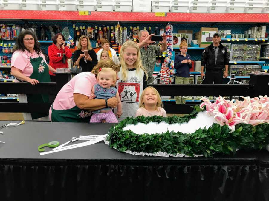 Half sisters standing behind garland of lilies