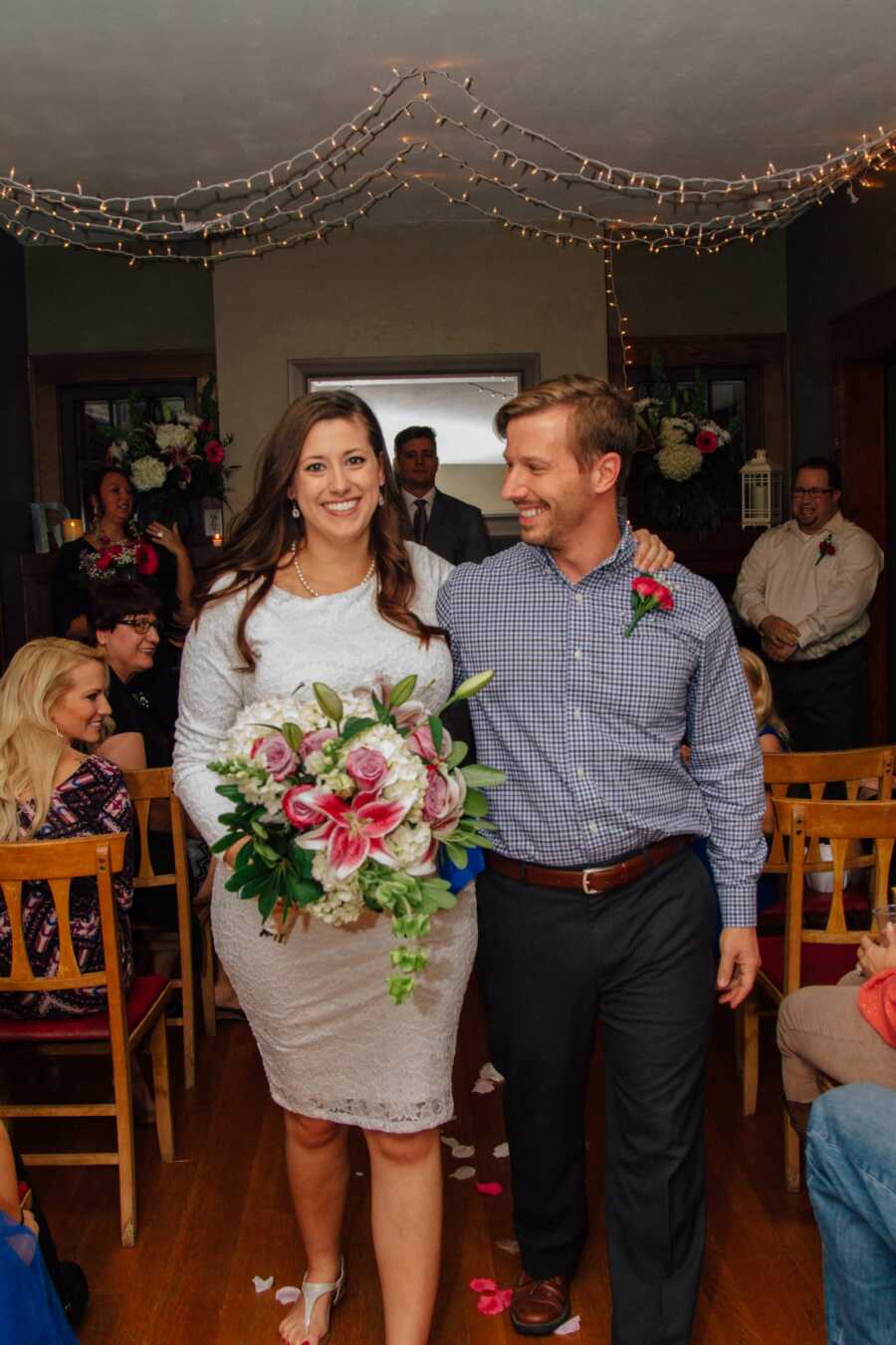 Husband and Wife walking down aisle after getting married in their old home