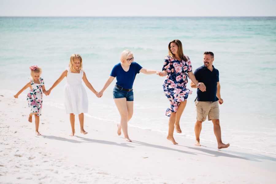 Family skipping on beach together