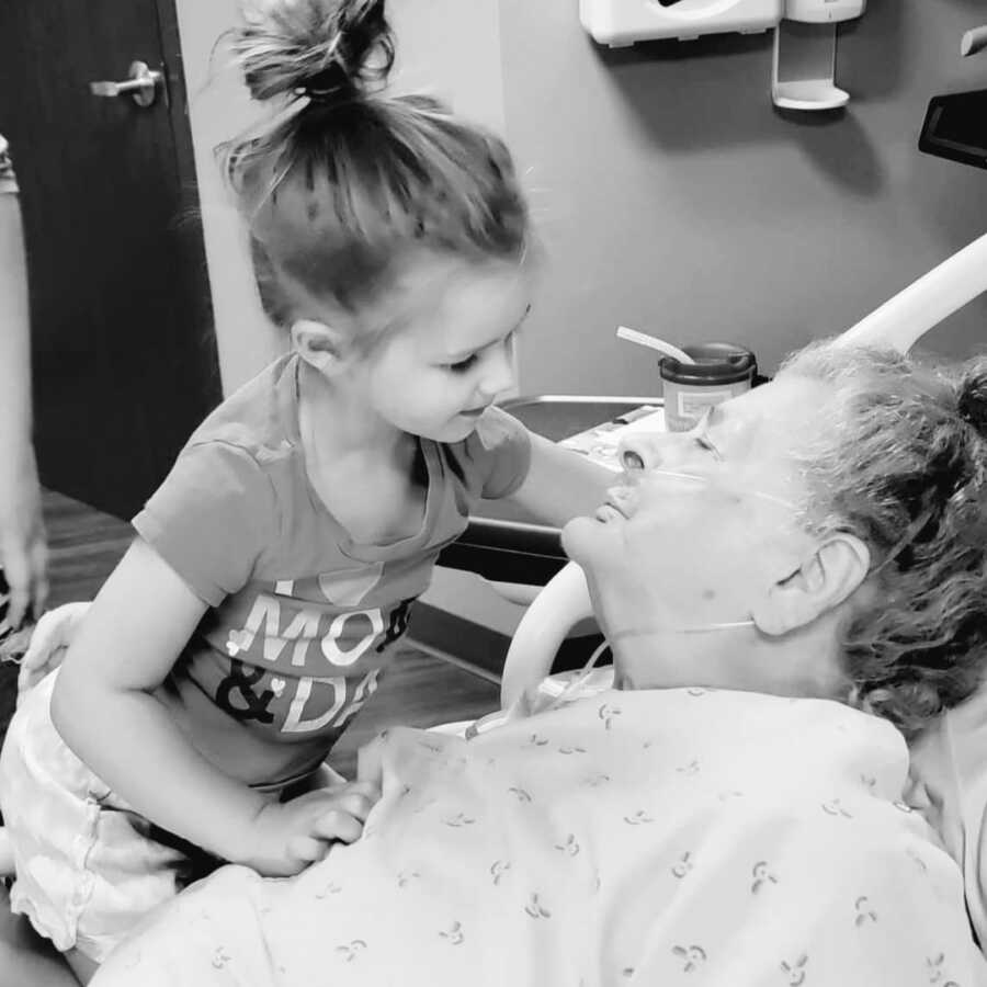 Grandmother in hospital bed holding her great, great granddaughter