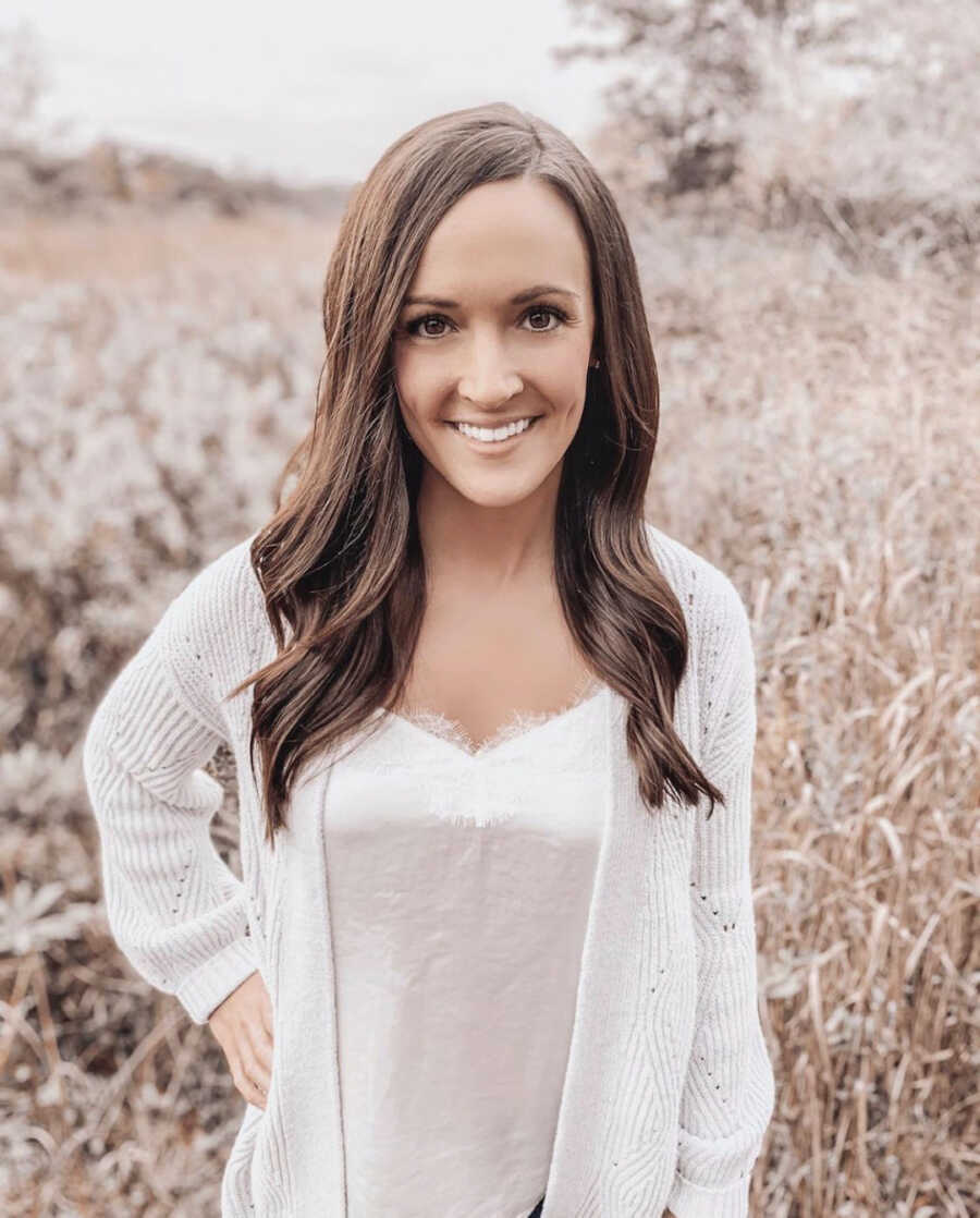 Woman standing in field smiling