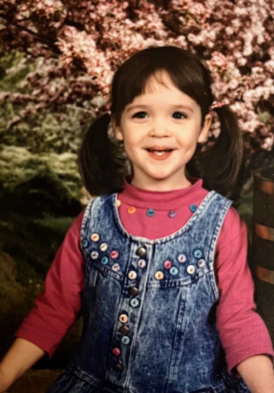 Young girl in overalls and pigtails smiling