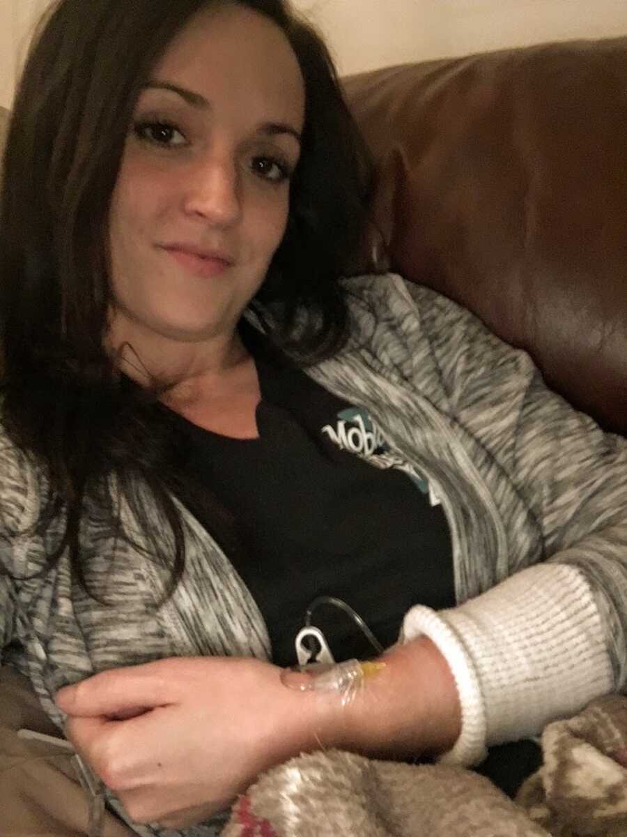 Woman lying on couch with iv strapped to wrist