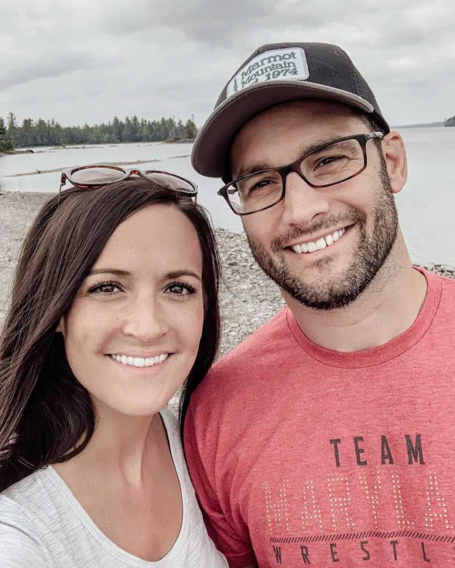 Husband and wife on rocky beach smiling