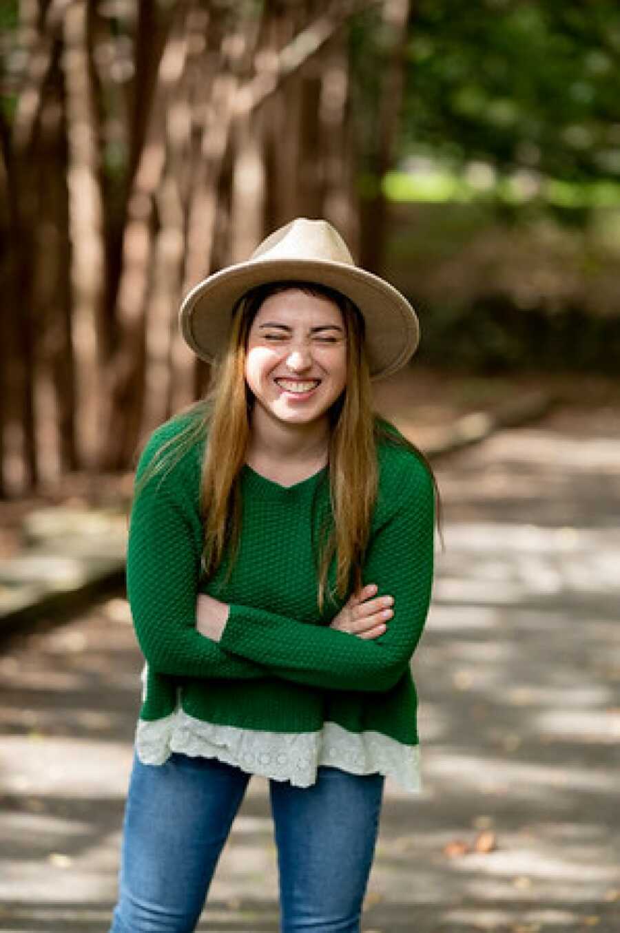 woman in a beige colored hat laughing