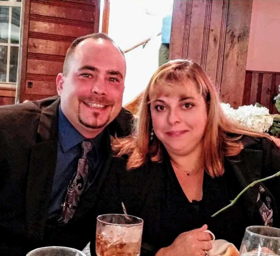 Husband and wife smiling at a dinner