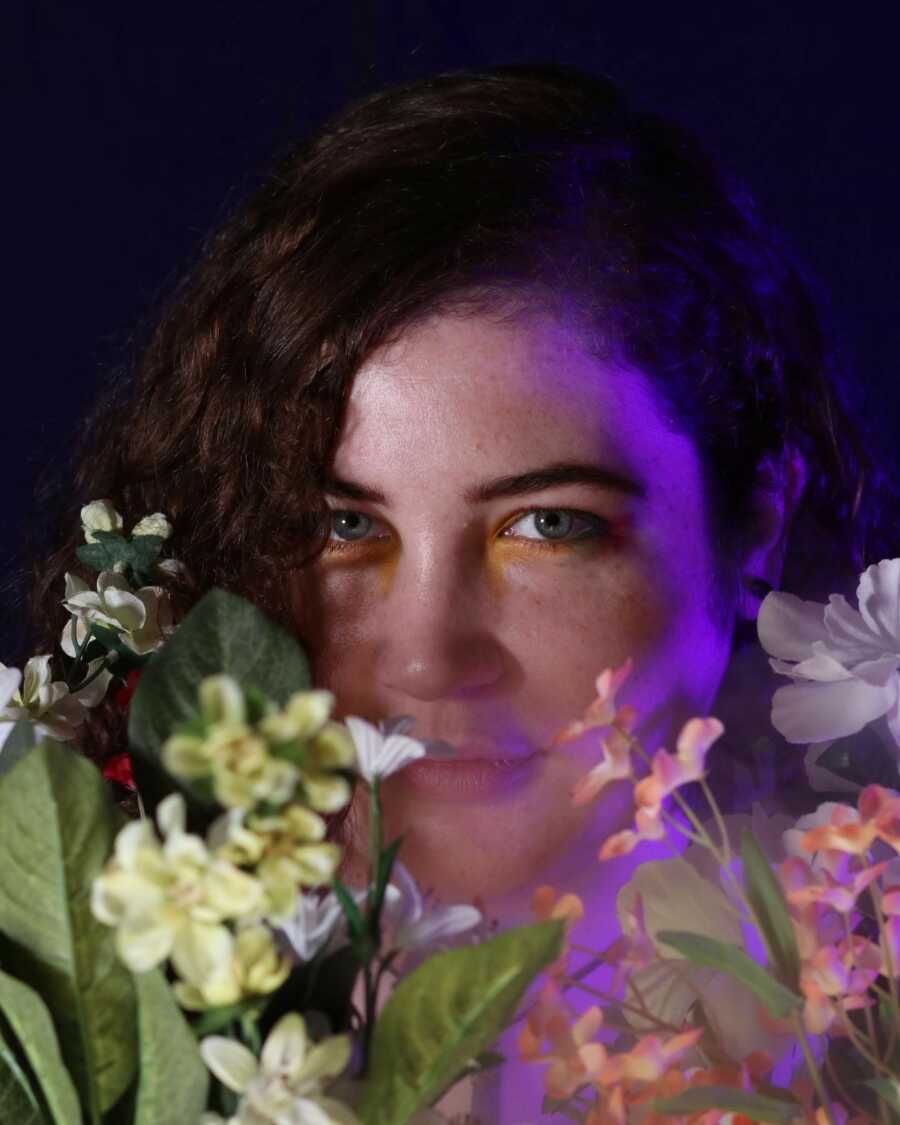 woman taking a picture with flowers around her face