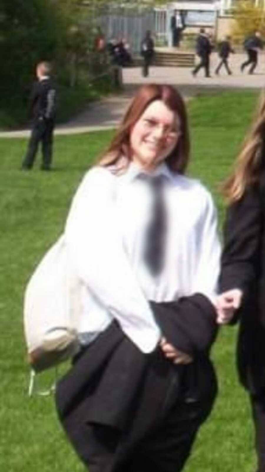 girl in school in uniform carrying a backpack