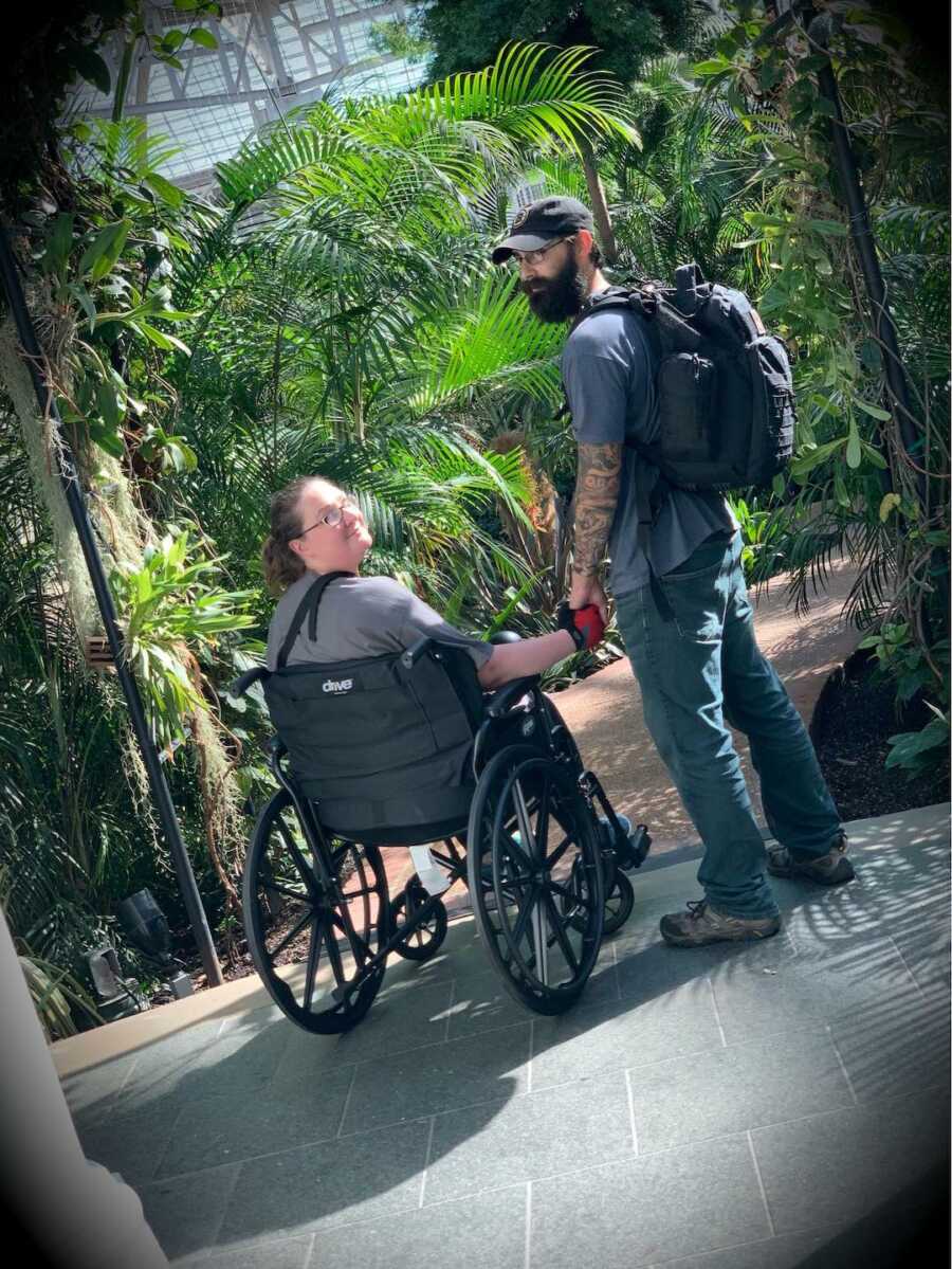woman in wheelchair while man holds her hand