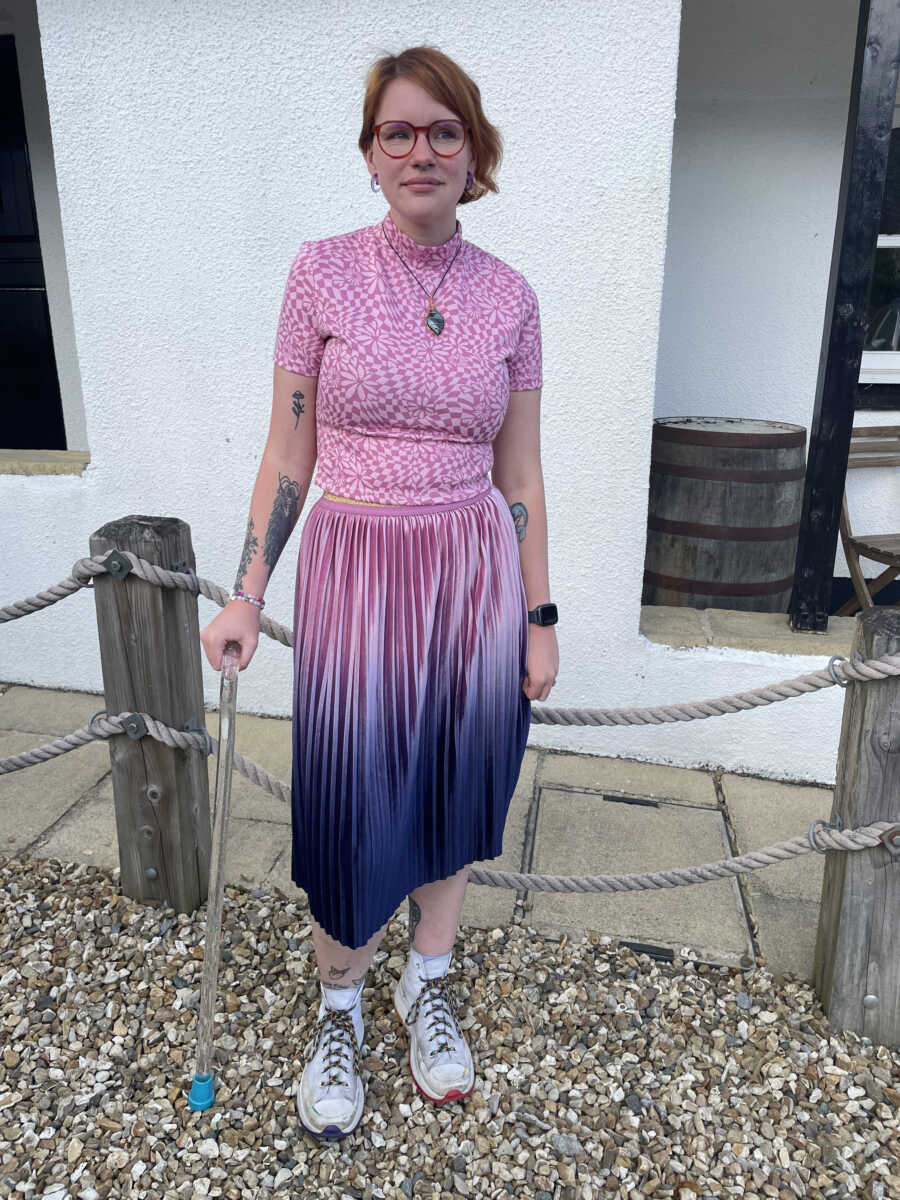 autistic woman in a pink dress smiling