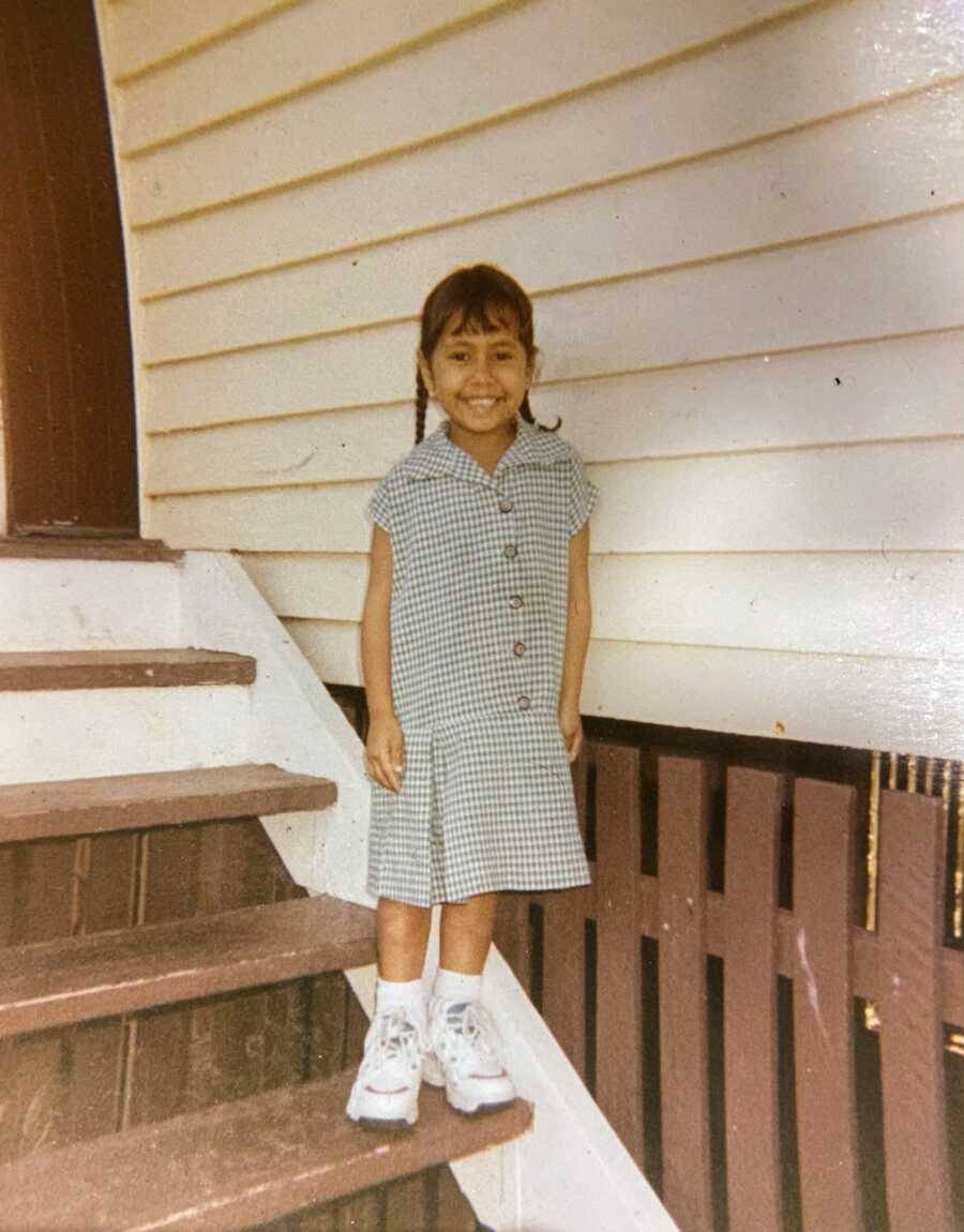 Aboriginal girl standing on front steps
