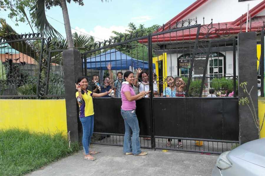 gates at orphanage with workers and other children