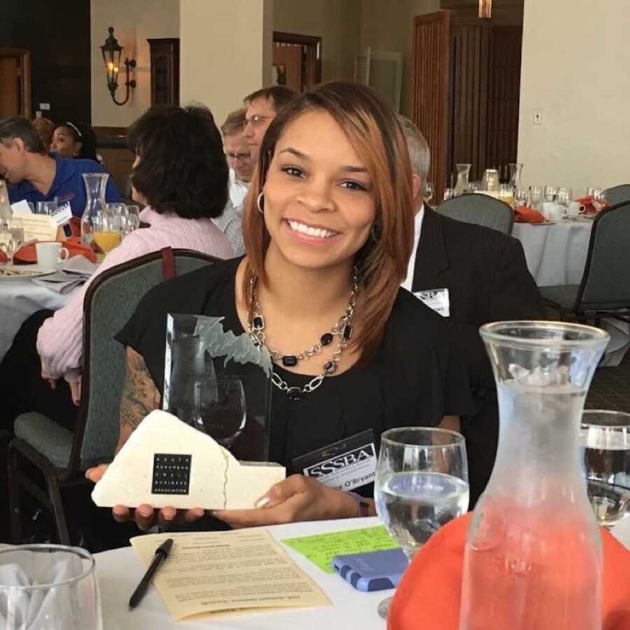 Woman with memory loss poses with awarded trophy