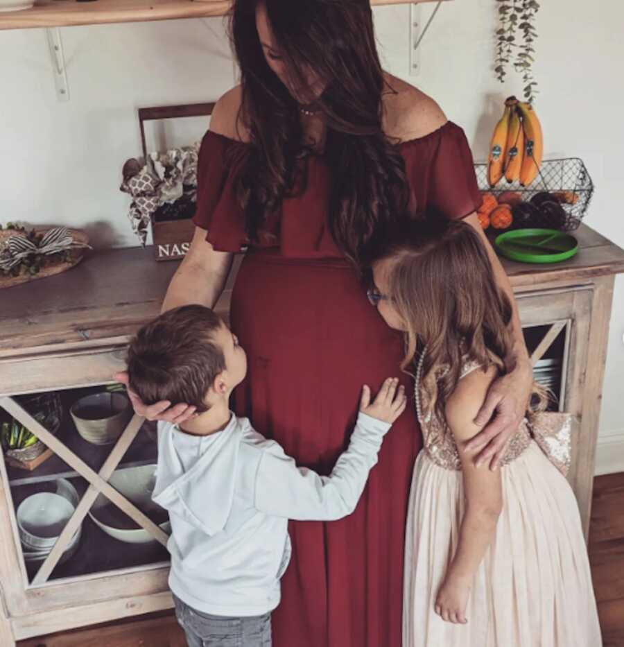 children kissing mothers pregnant belly