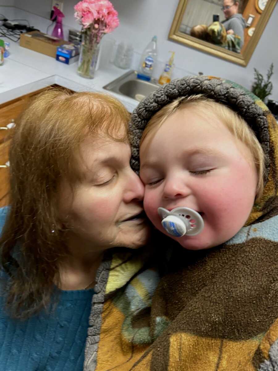 grandma puts her face close to her grandson's face