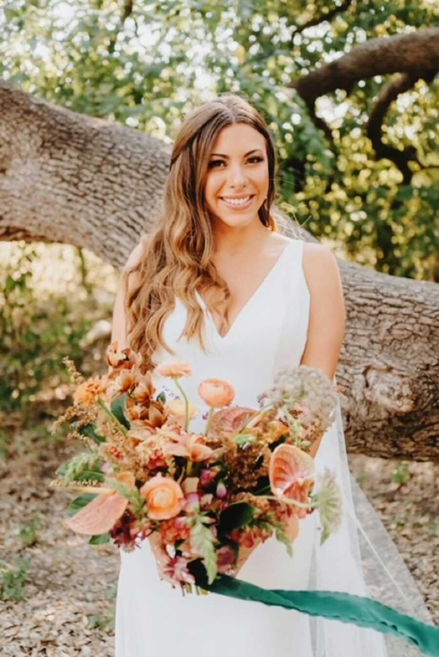 A bride holds a bouquet of pink flowers