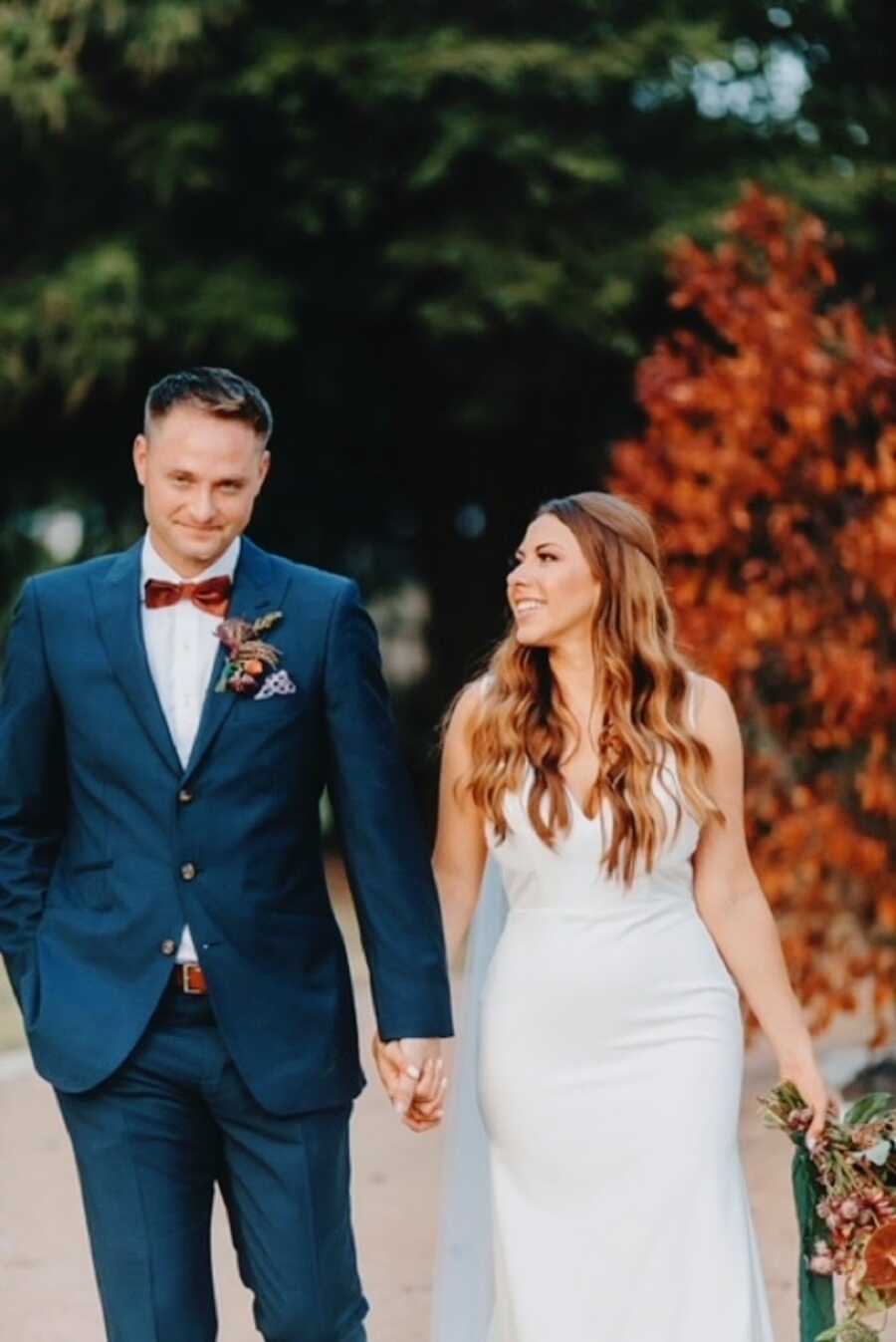 A woman and her husband hold hands and walk together