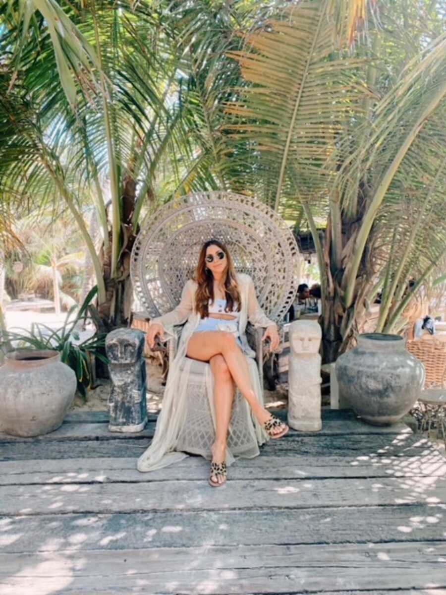 A woman sits in a large outdoor chair