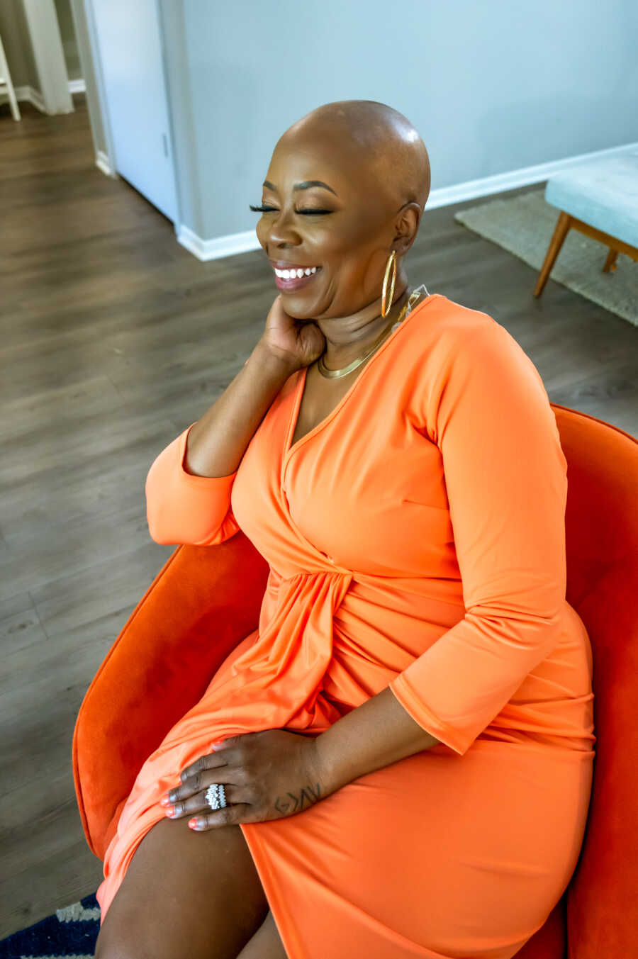 woman with alopecia in a vibrant orange dress