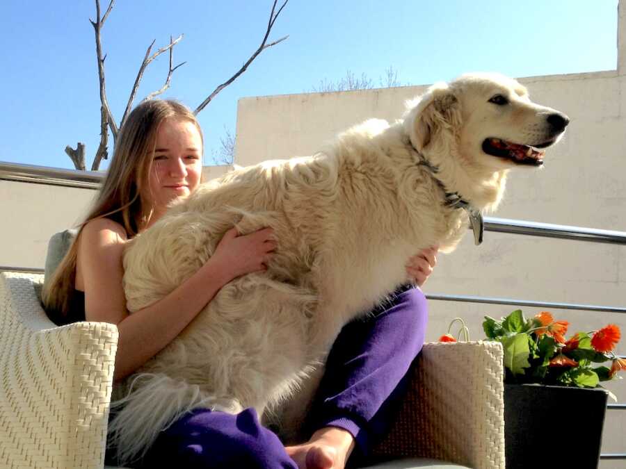 girl in recovery from an eating disorder sits with a dog on her lap