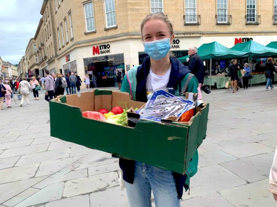 girl in recovery from anorexia holds a box full of produce