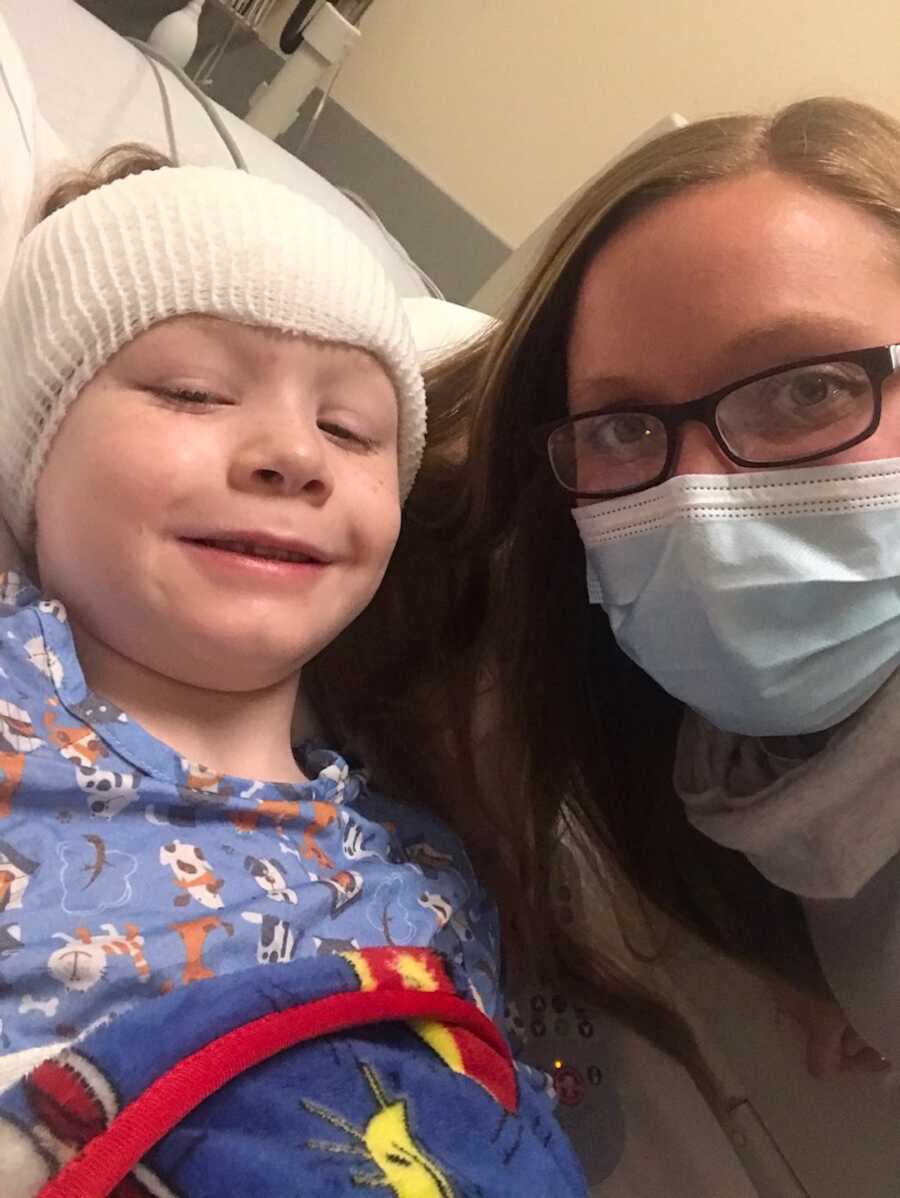 boy in hospital with mother next to him 