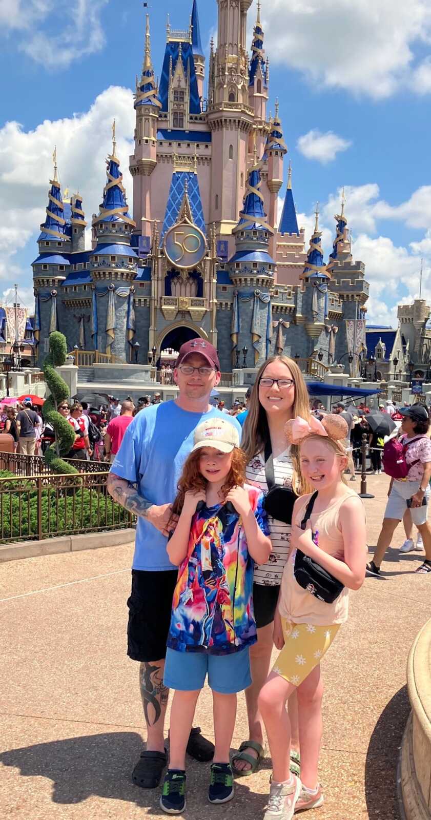 family standing outside castle at Disney 