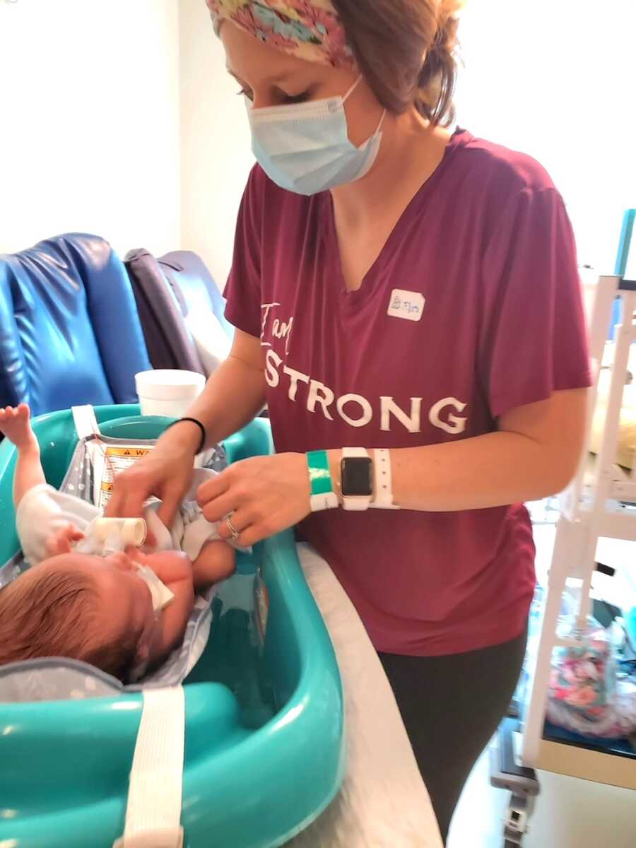 mom gives her baby a bath while in the NICU