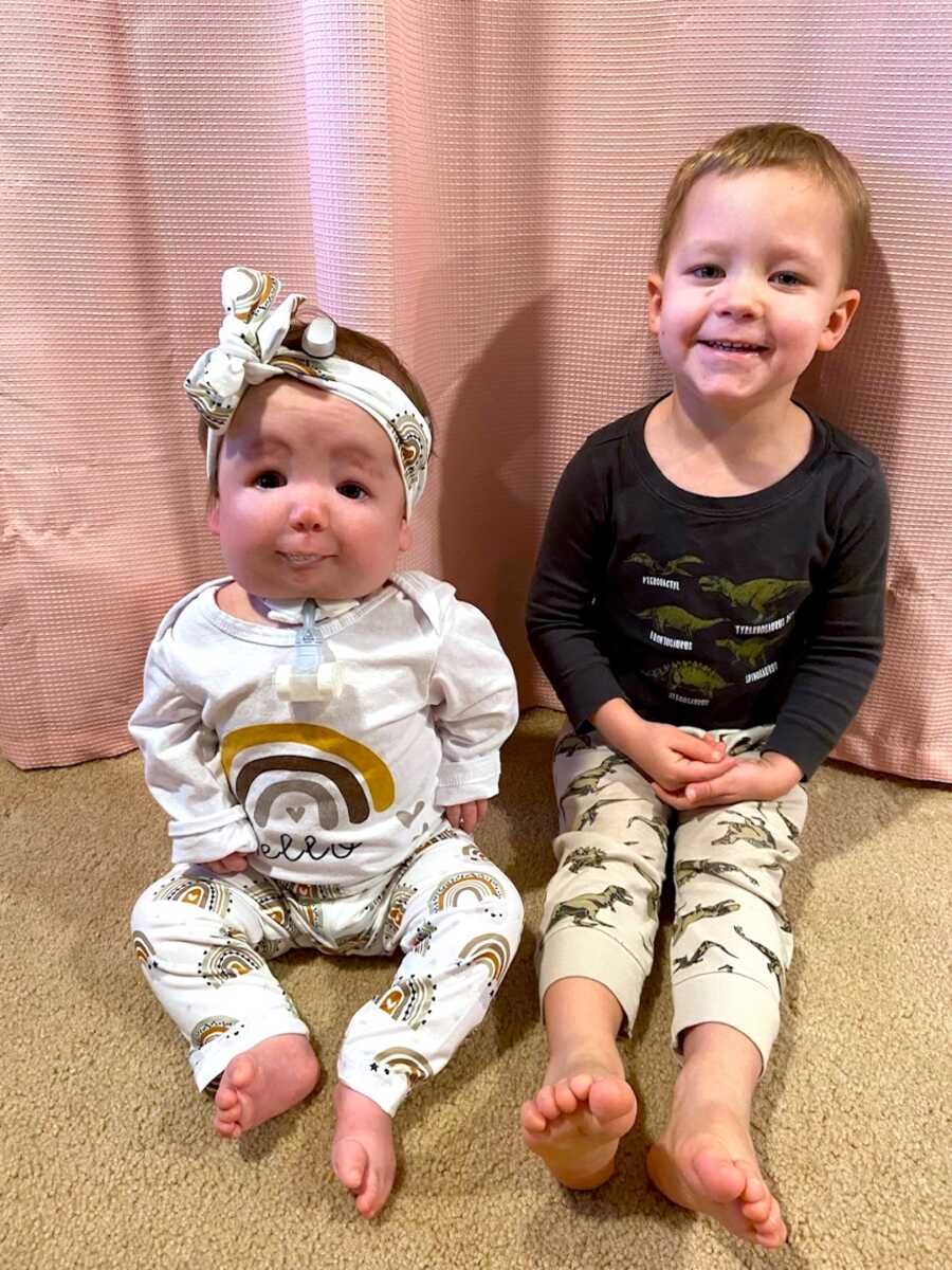 siblings sit next to one another, older brother with little sister