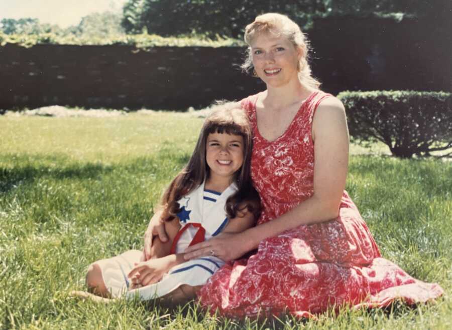 little girl being held by her mom