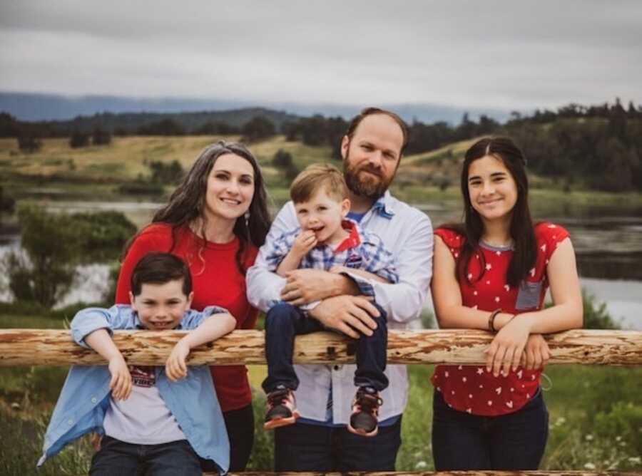 parents stand with their children, one from adoption and two boys through pregnancy