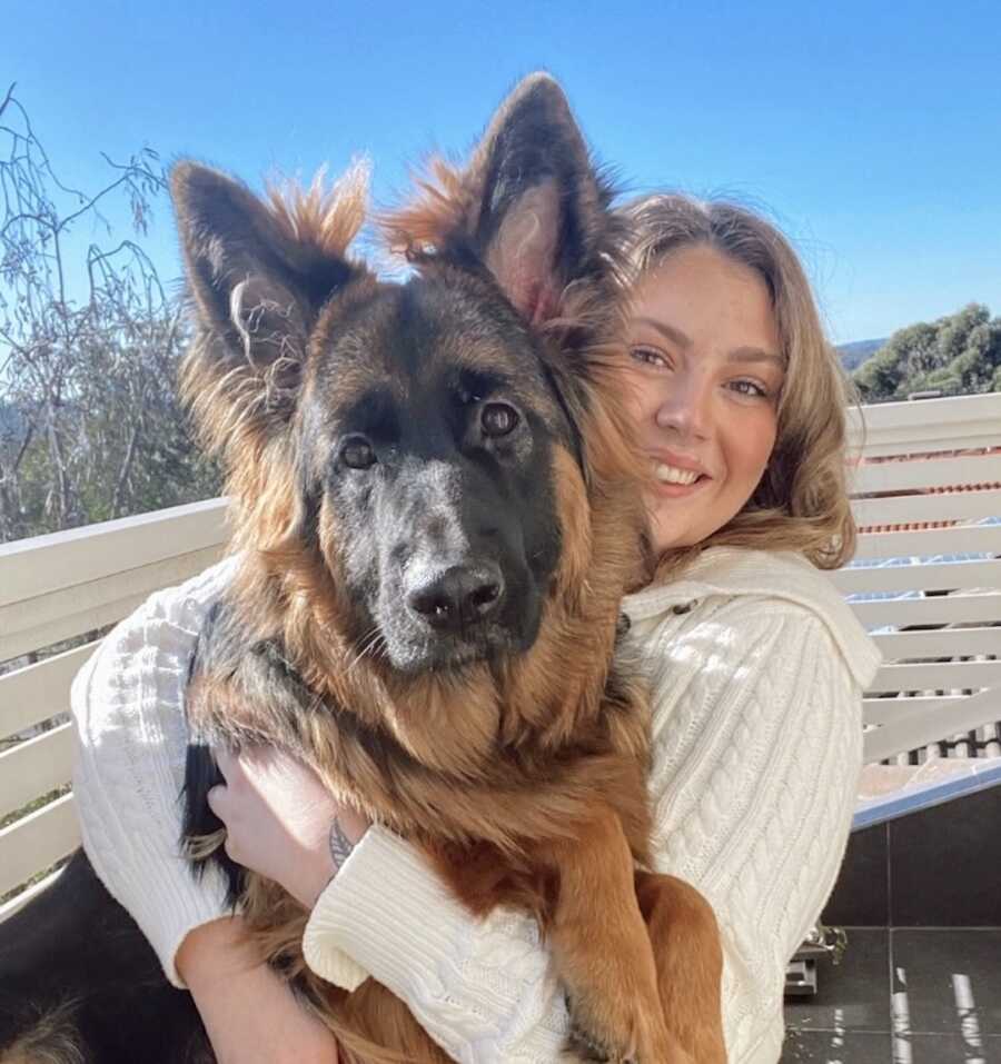 suicide survivor holds her dog while smiling